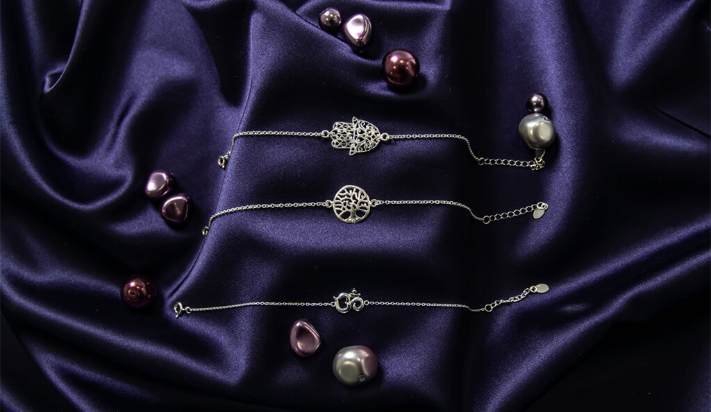 Stříbrné šperky na fialovém pozadí